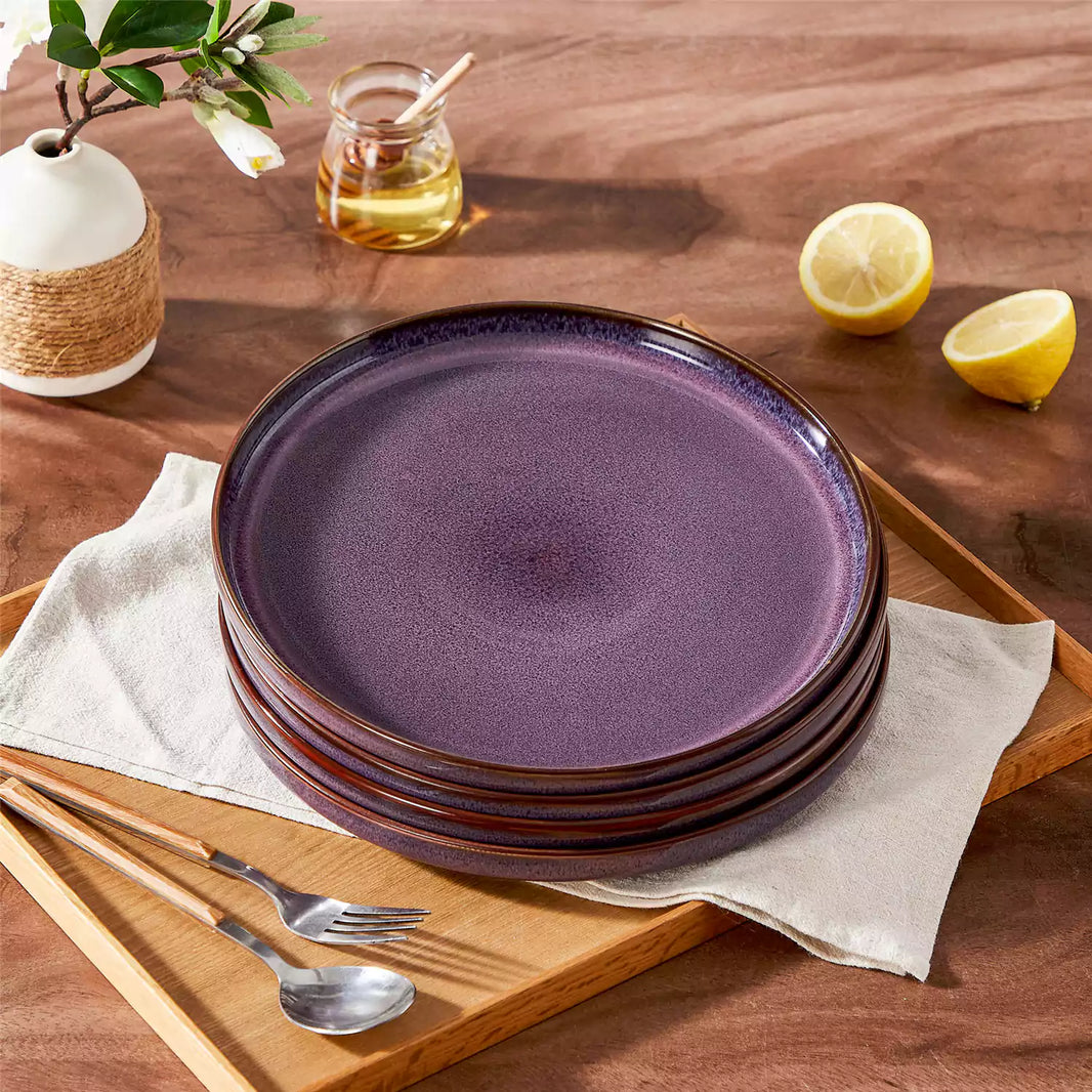 Sata purple stoneware dinner plates set of 4 stacked featuring farmhouse reactive glaze finish styled on wood dining table with lemon and white floral vase.