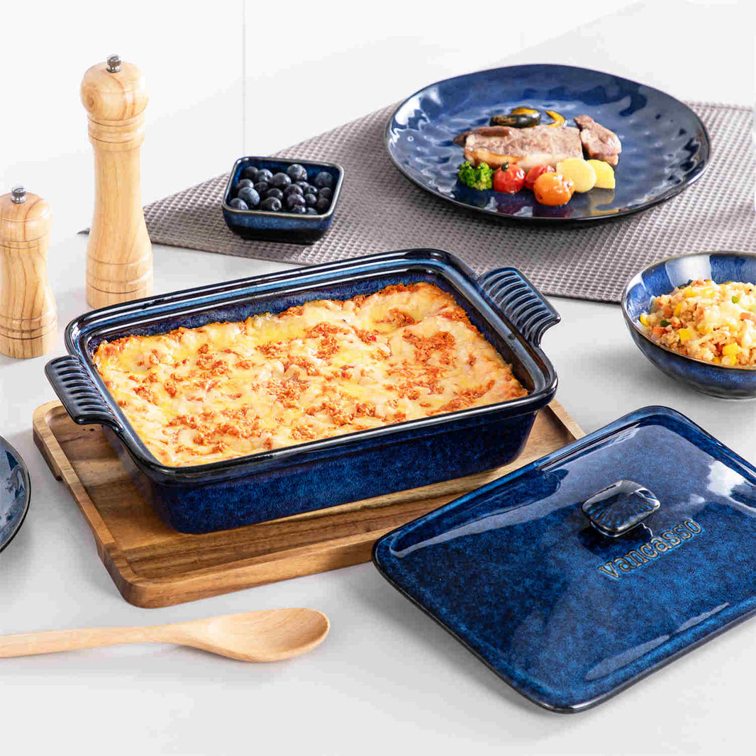 Starry casserole dish with baked cheese ham, blueberries in dipping dish, on a white modern table.