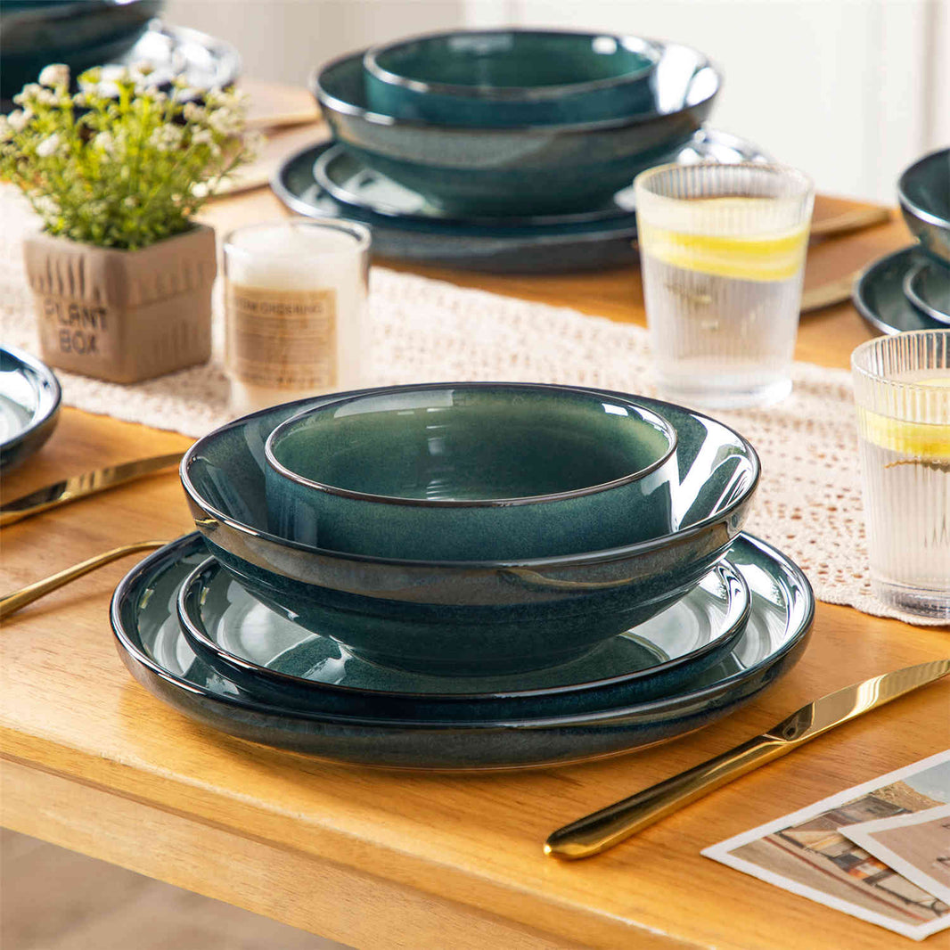 Starry 24-piece green stoneware dinnerware set stacked on a cream table with a lace runner, candle, greenery, and lemonade.